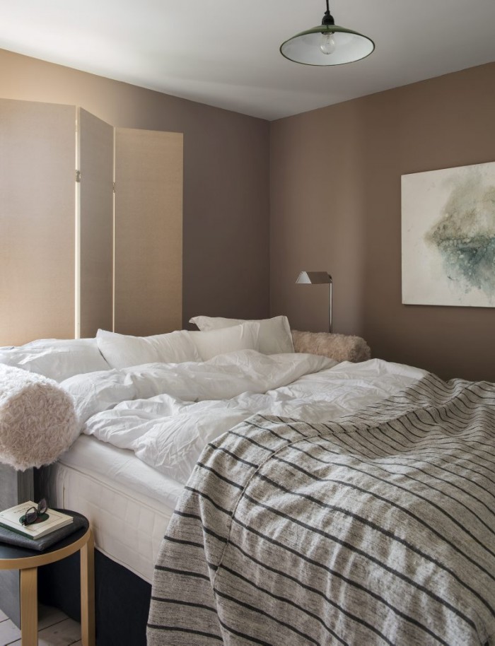 I sovrummet råder asketiskt lugn med lite lurv på sänggaveln. Säng och vikskärm är i egen design. Lampor inropade på auktion. Överkastet är en Kelimmatta.