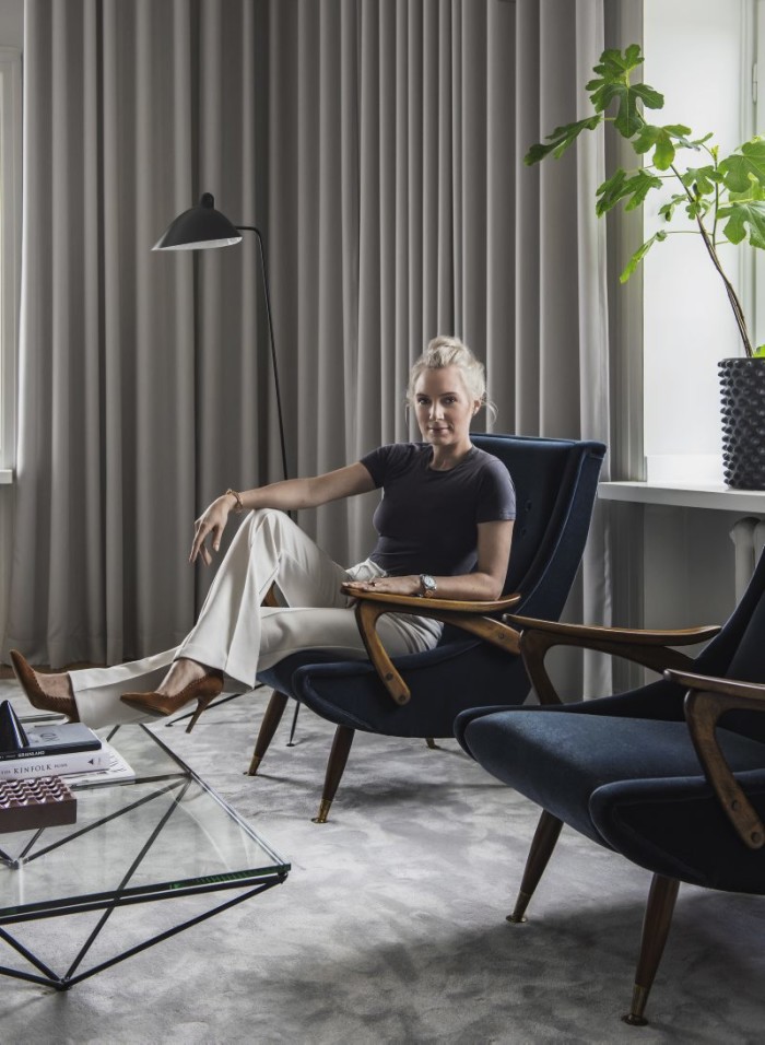 Hanna sitter i sina auktionsfynd, två fåtöljer som kläddes om i sammet. Krukor Hannas egen design, kan köpas via hannasroom.com. Golvlampa, Serge Mouille.