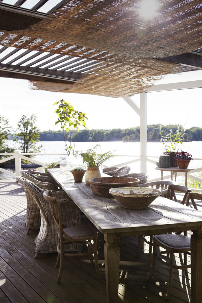 På den stora terrassen som ligger i söderläge har Johan och Victoria ställt två rejäla bord för alla gästabud. I taket hänger vassmattor som skuggar mot solen. I ekfaten i bakgrunden växer fliksumak och tulpanträd.