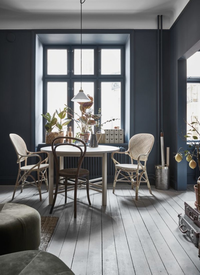 Framför fönstret står matbordet Björksnäs från Ikea. Rottingstolar Rossini från Sika design/Artilleriet och en Thonetstol köpt på auktion. Taklampa från Byggfabriken. I förgrunden skymtar sittpuffar i sammet från Normann Copenhagen.