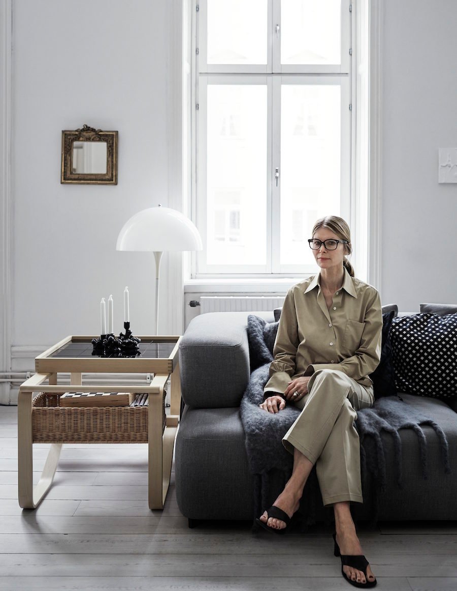 Anna Teurnell sitter i sin soffa i kläder från Arket.